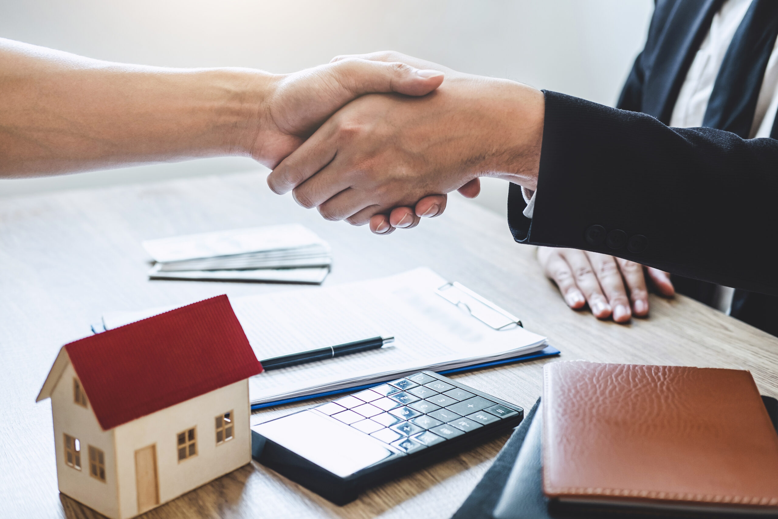 Finishing to successful deal of real estate, Broker and client s Hausmodell und Handschlag